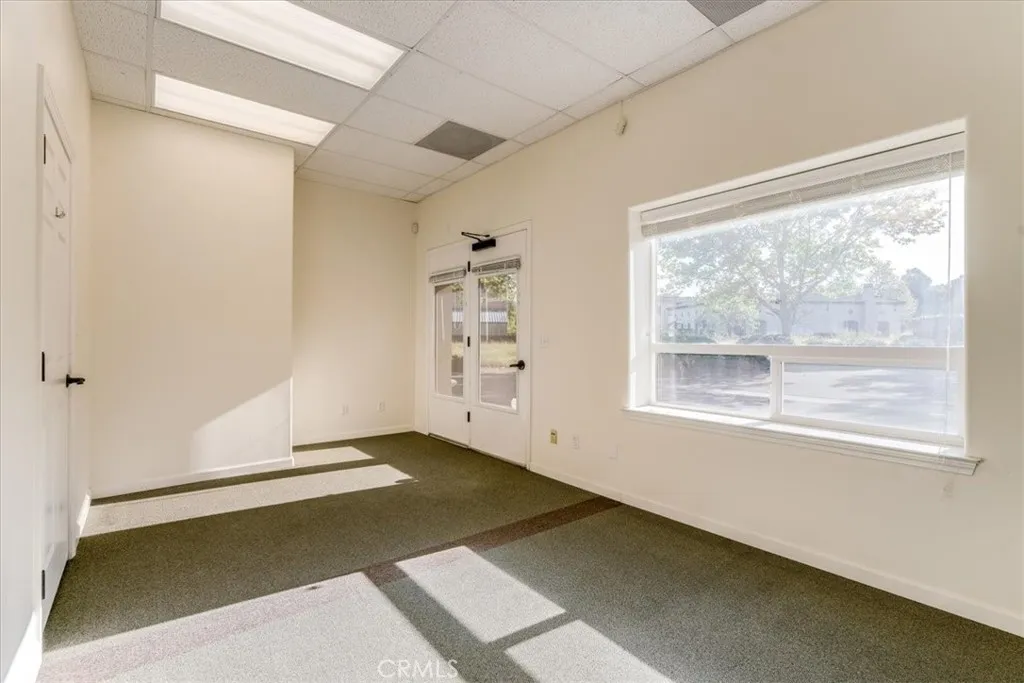 Large office facing parking lot with exterior entrance and two doors into hallways