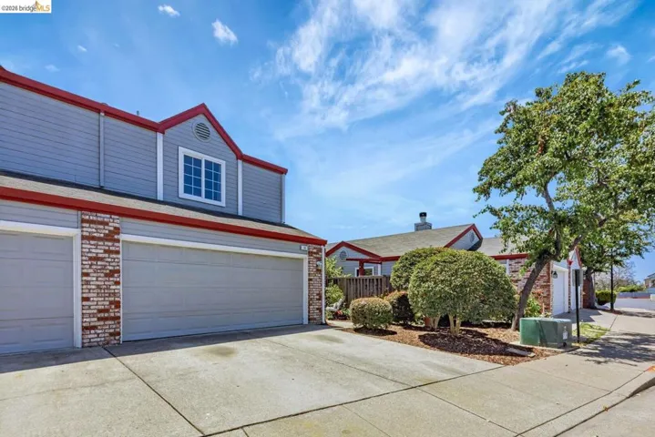 traditional home with driveway, brick siding, and an attached garage