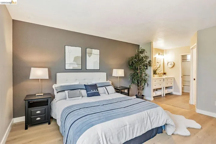 bedroom featuring light wood-type flooring and ensuite bath