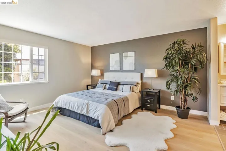 bedroom featuring wood finished floors and ensuite bathroom