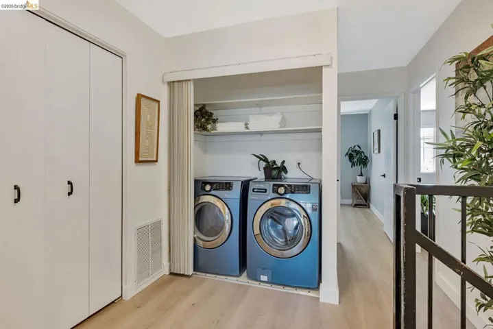 laundry area with light wood-style flooring and washing machine and dryer