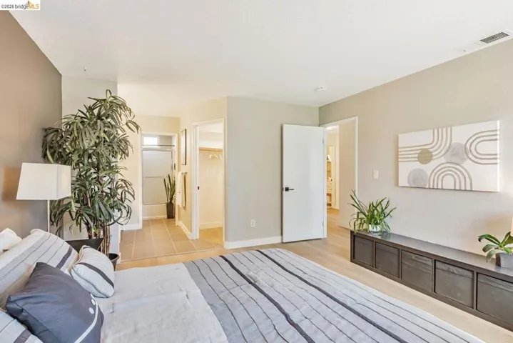bedroom with a walk in closet and light wood-type flooring