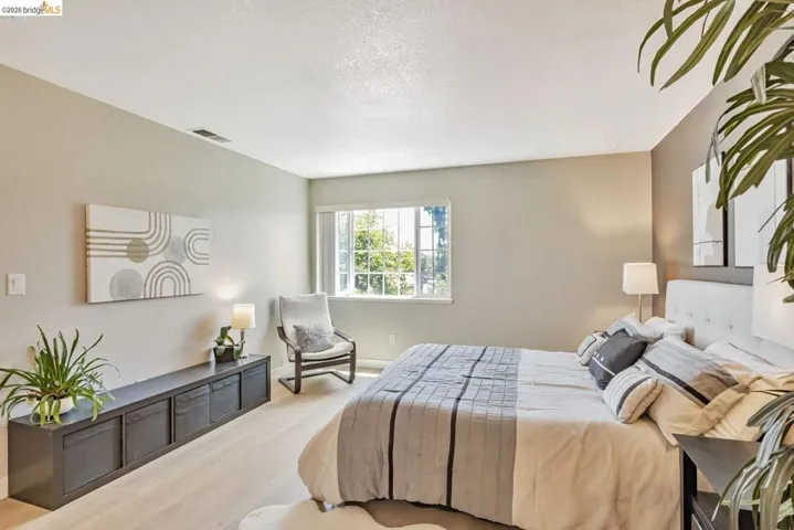 bedroom with light wood-style floors and a textured ceiling