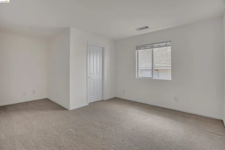 Spare room with light carpet and baseboards