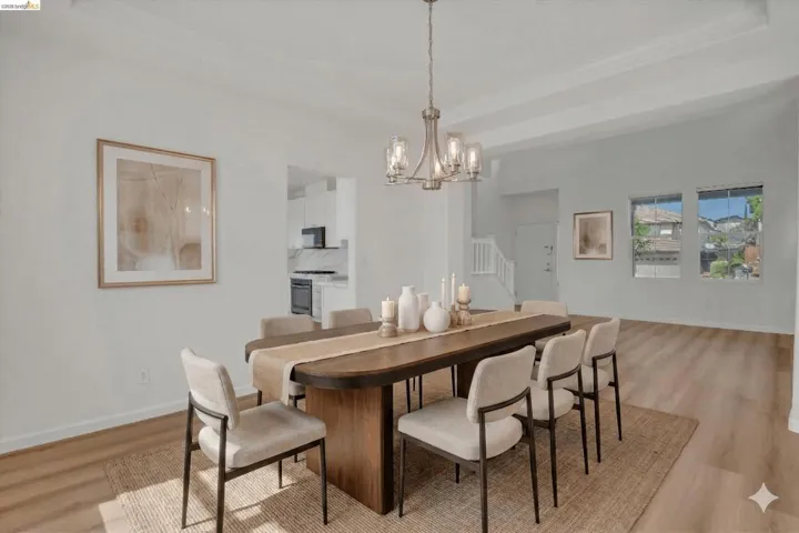 Dining room featuring hanging lights, light wood finished floors, and a raised ceiling