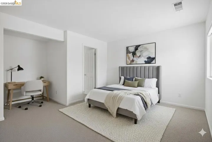 Bedroom with light carpet and an office area
