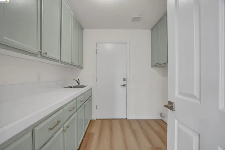 Laundry area featuring light wood-style floors and a sink