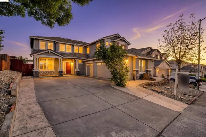 Craftsman-style house featuring stone siding, driveway, a tiled roof, and stucco siding