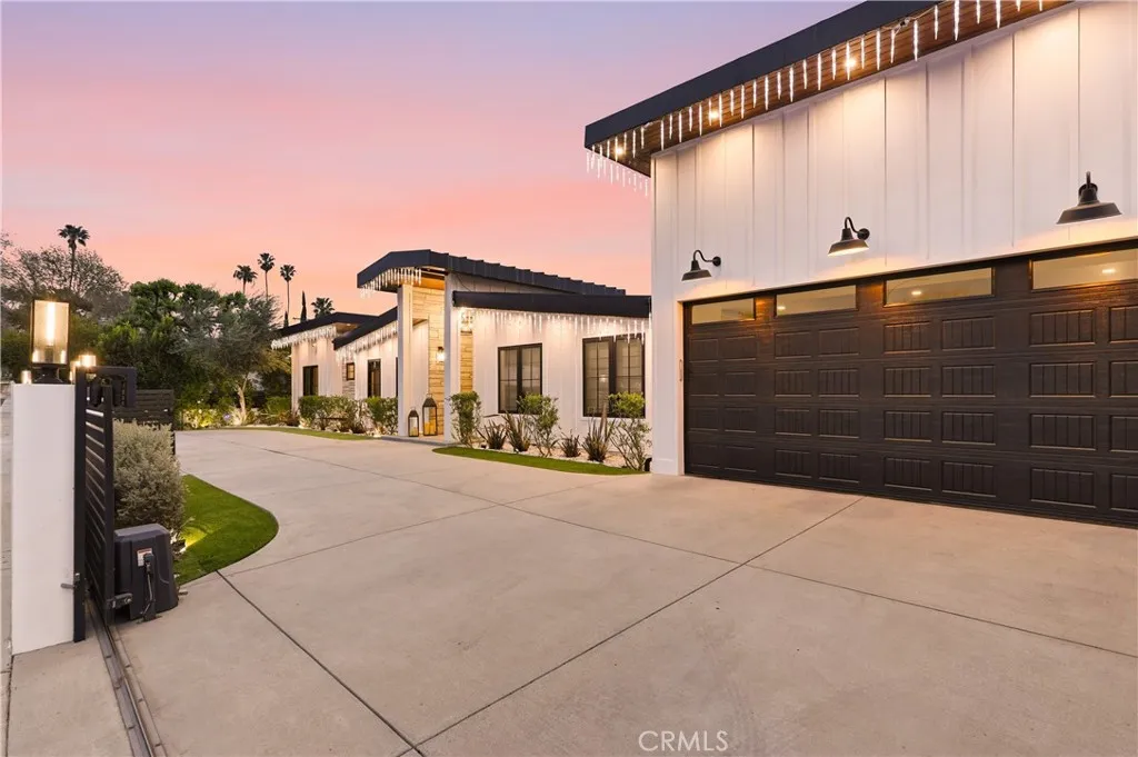 Farmhouse style design behind stone & metal fence with privacy hedges all around!