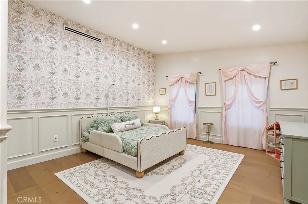 Bedroom 1 offers wainscoting all around and wallpaper.