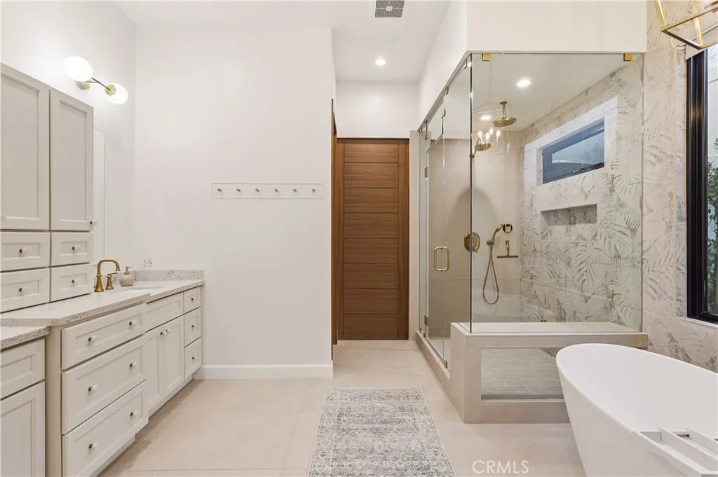Primary bathroom with enclosed steam shower, stand-alone bathtub, his/ hers sinks and private water closet.