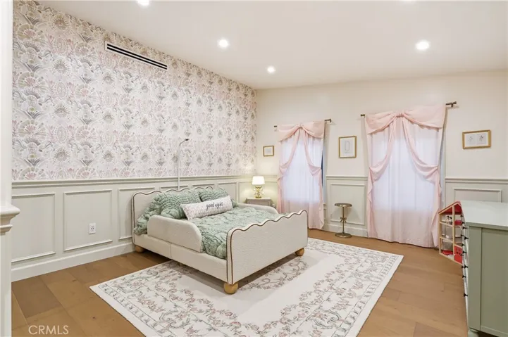 Bedroom 1 offers wainscoting all around and wallpaper.
