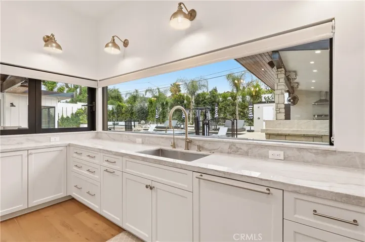 Wall to wall picture window facing the amazing backyard, with a fully opening Fleetwood bi-fold countertop door ideal when entertaining outdoors!