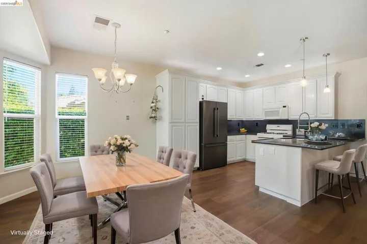Kitchen with white appliances, white cabinetry, a peninsula, and dark wood-style floors