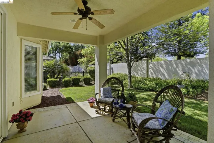 Fenced backyard with a patio and ceiling fan