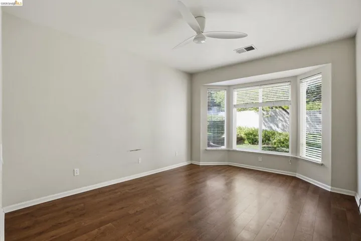 Unfurnished room with a ceiling fan and dark wood finished​​‌​​​​‌​​‌‌​​‌​​​‌‌​​​‌​​‌‌​​‌‌​​‌‌​​​​ floors