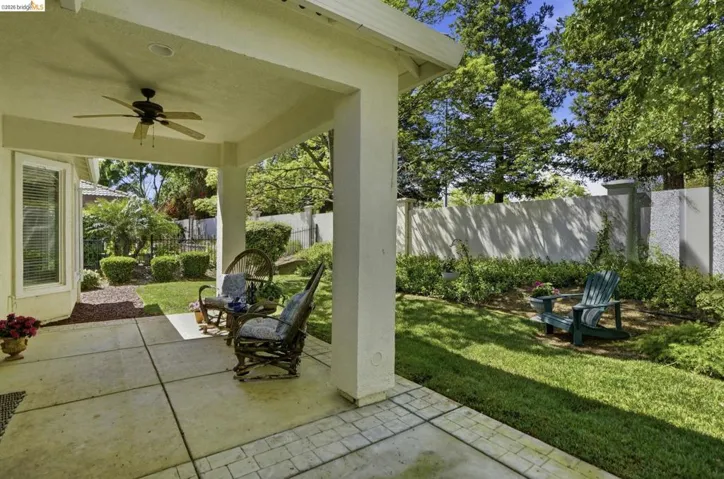 Fenced backyard featuring a patio and ceiling fan