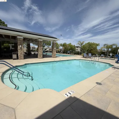 Community pool with a patio