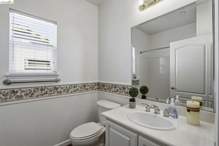Bathroom featuring a textured wall, vanity, and a shower