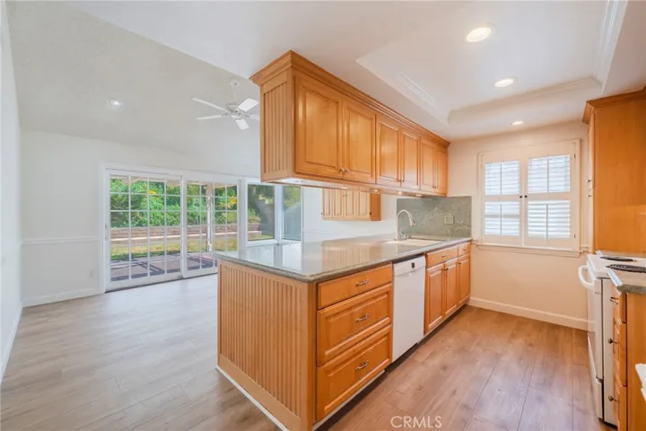 Kitchen open to dining and backyard views.