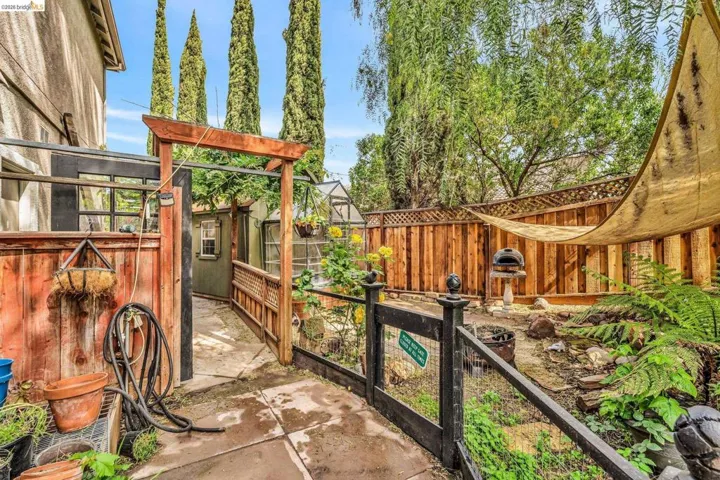 Fenced backyard featuring an exterior structure, an outbuilding, and a patio