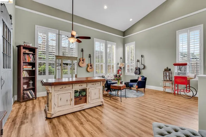 Living area with lofted ceiling, light wood finished floors, recessed lighting, and a ceiling fan