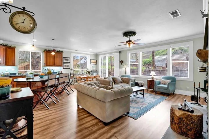Living room featuring light wood-style floors, a ceiling fan, ornamental molding, and recessed lighting
