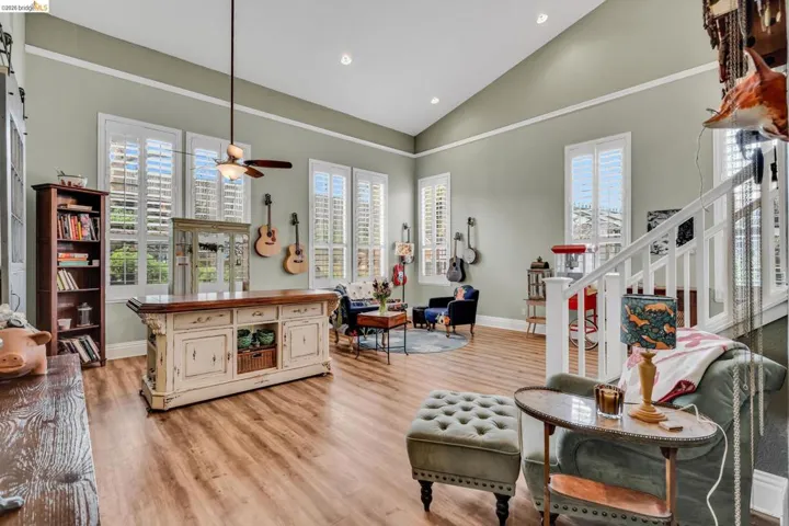 Living area featuring vaulted ceiling, light wood finished floors, plenty of natural light, ceiling fan, and recessed lighting