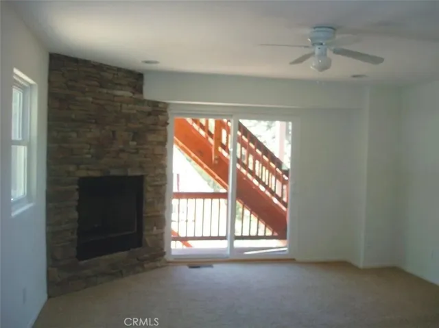 Bottom floor living room with fireplace & deck access.
