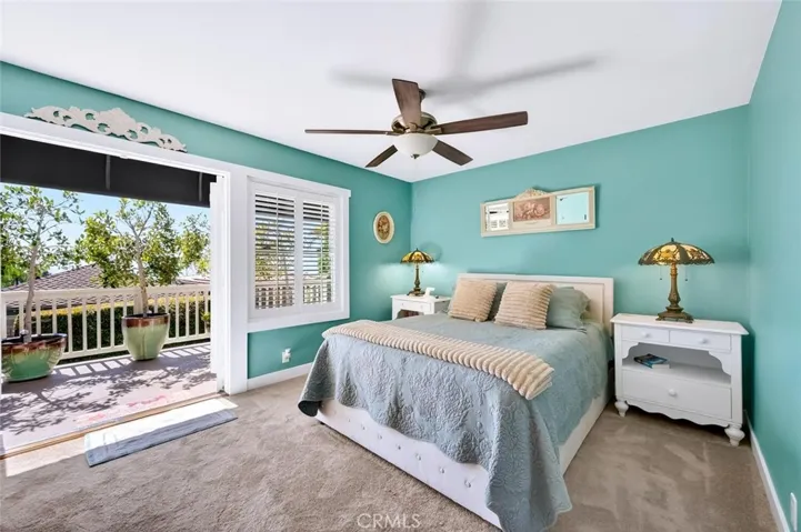 Primary bedroom with French doors out to a peaceful ocean view deck.