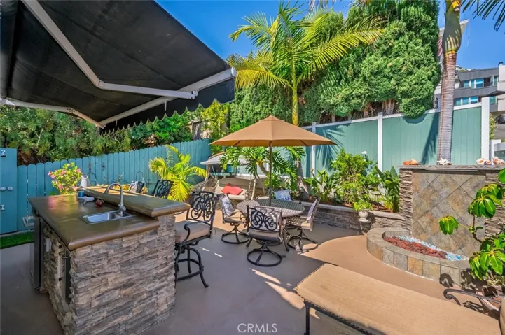 Backyard with outdoor kitchen and fir pit.