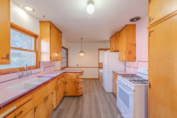 kitchen with newer flooring leading to eat in kitchen area