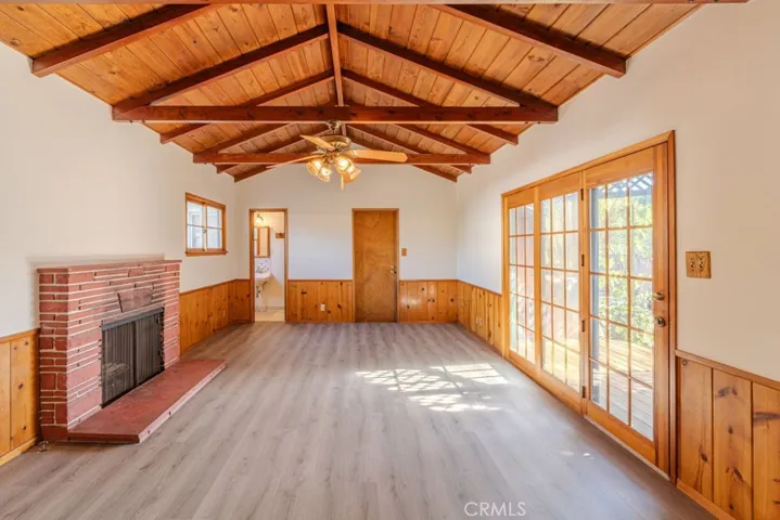 Den with a fireplace and sliding doors to the covered patio