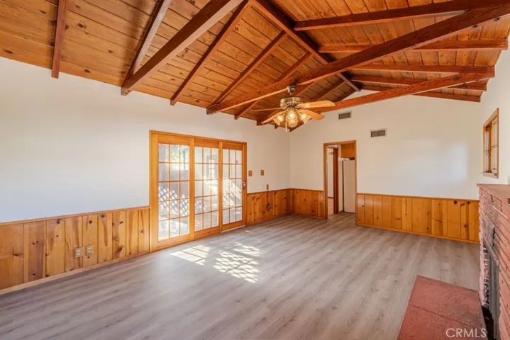 Den features exposed beam vaulted ceilings