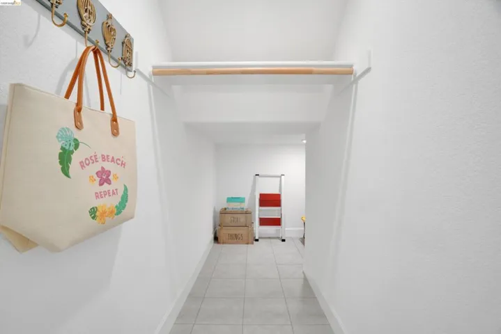 Hallway featuring baseboards and light tile patterned floors