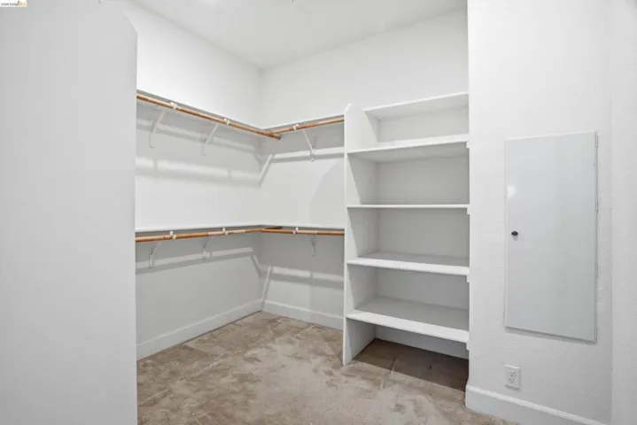 Walk in closet featuring light colored carpet