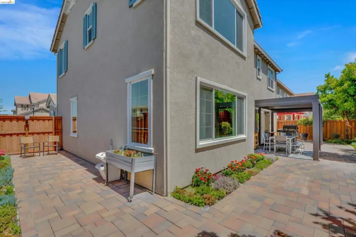 Rear view of property with a patio area, a fenced backyard, outdoor dining space, and stucco siding