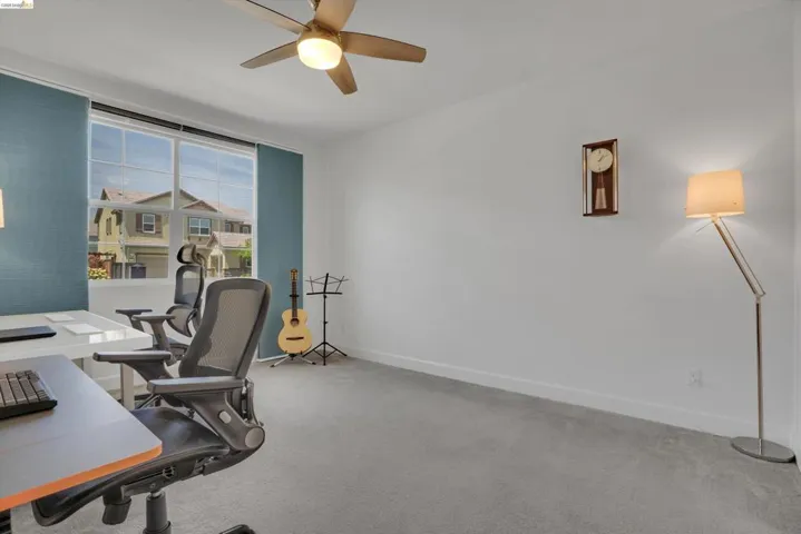 Home office featuring light carpet and a ceiling fan