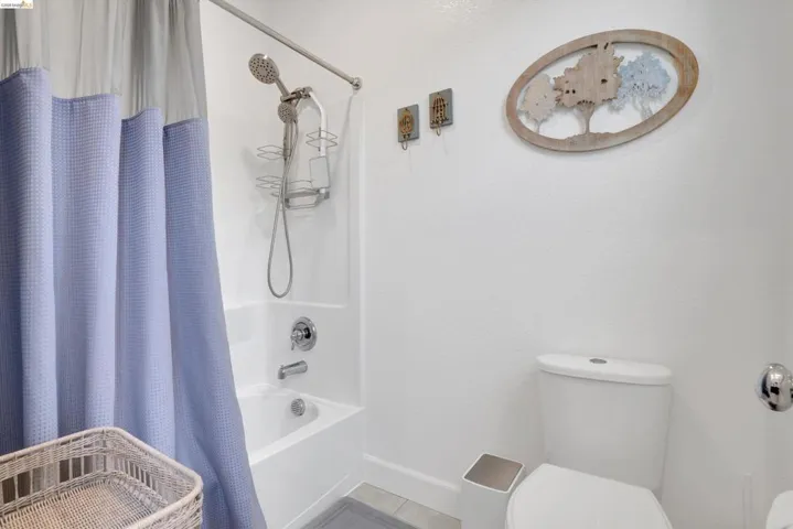 Bathroom featuring toilet and shower / tub combo