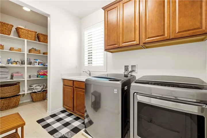 upstairs laundry with sink and storage