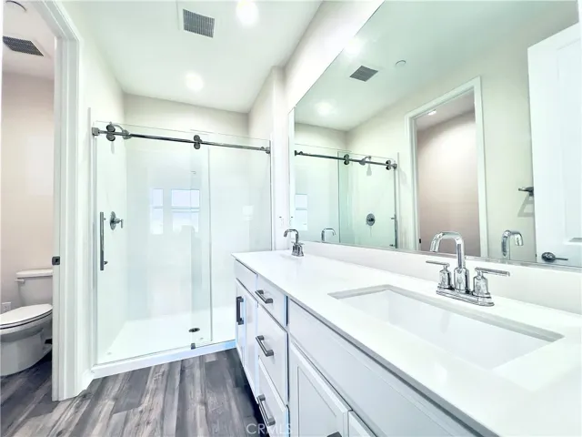 Primary bedroom bath with dual sinks and standing shower