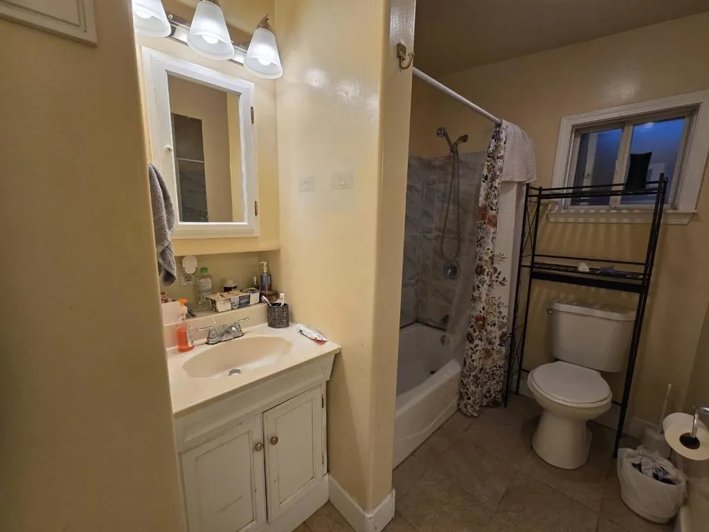 bathroom with tile floor and tub tile surround