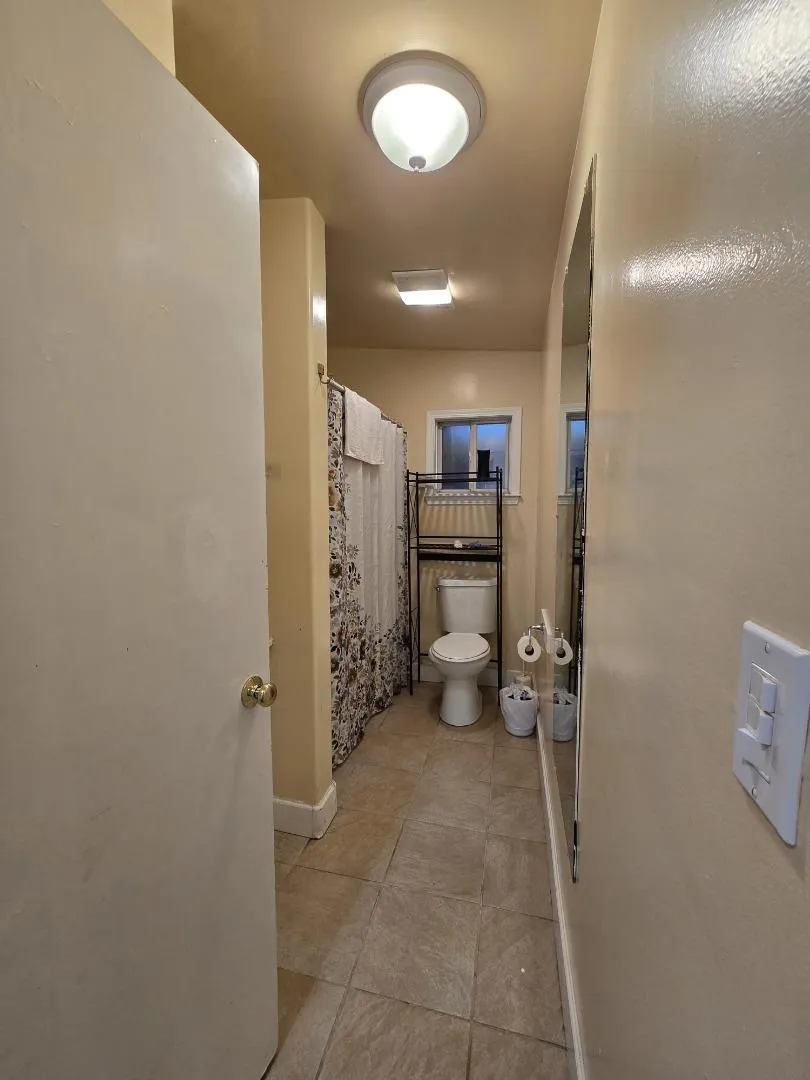 bathroom with tub and shower over tub