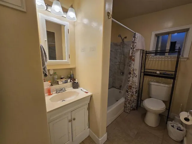 bathroom with tile floor and tub tile surround