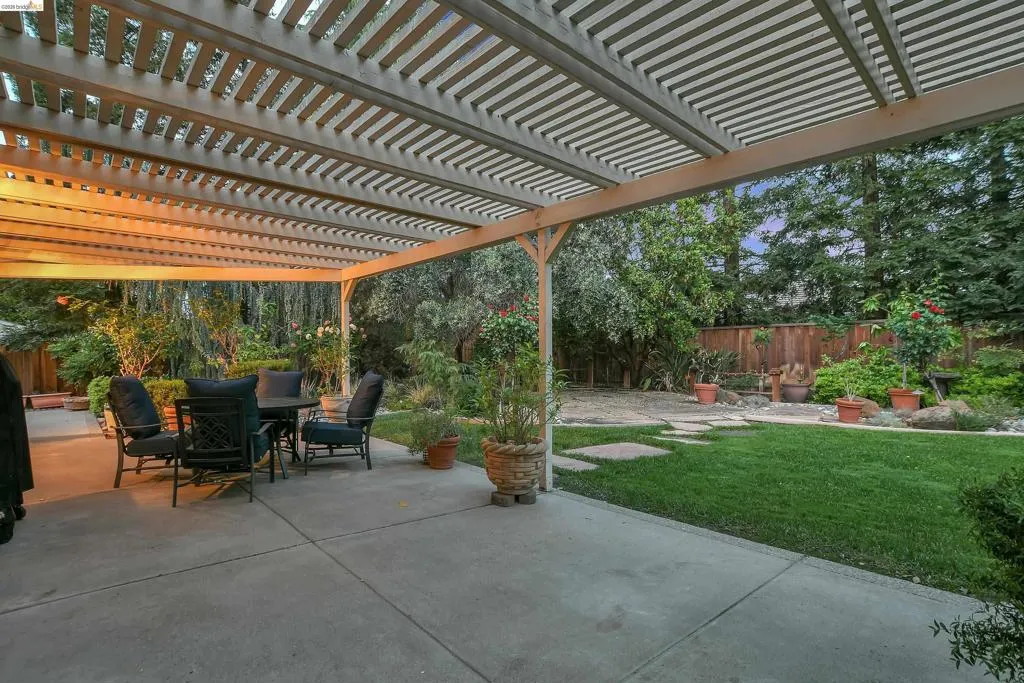 Fenced backyard with outdoor dining area and a patio