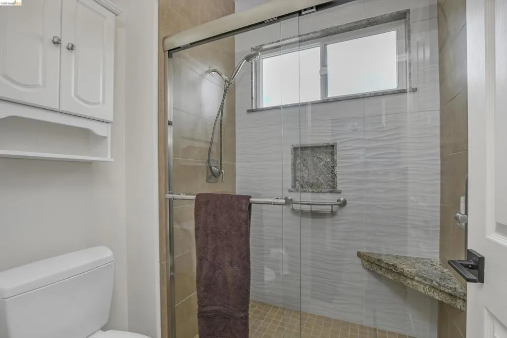Full bathroom featuring a shower stall and toilet