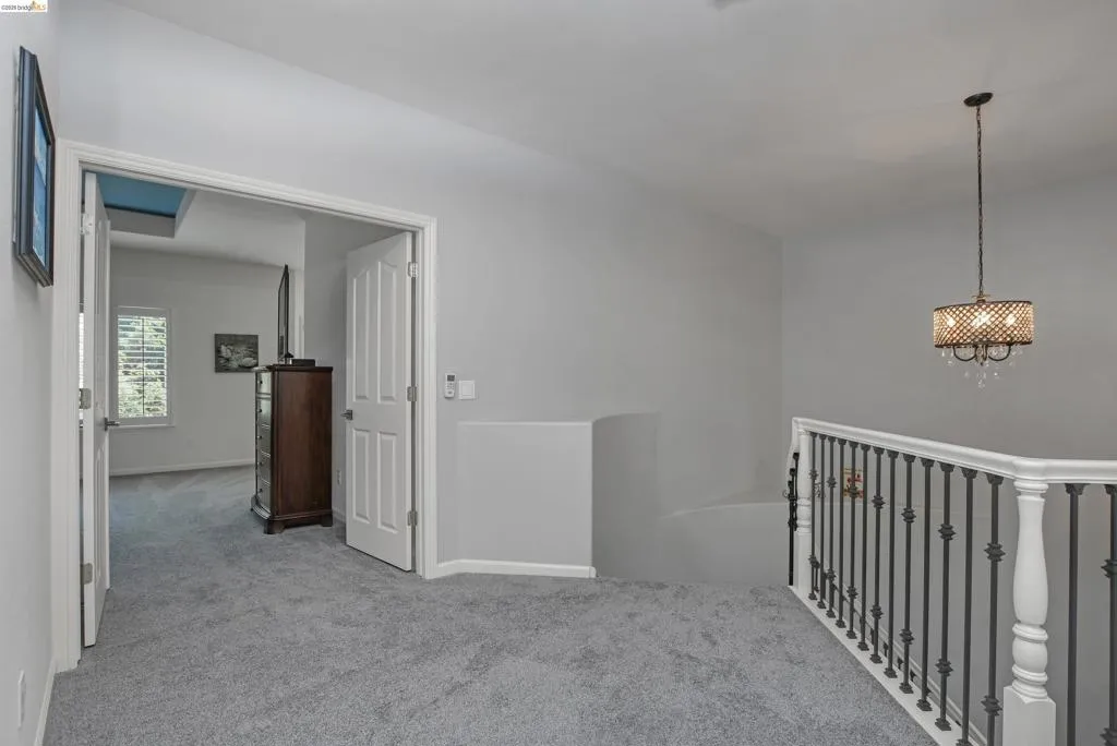 Hall with light carpet and an upstairs landing
