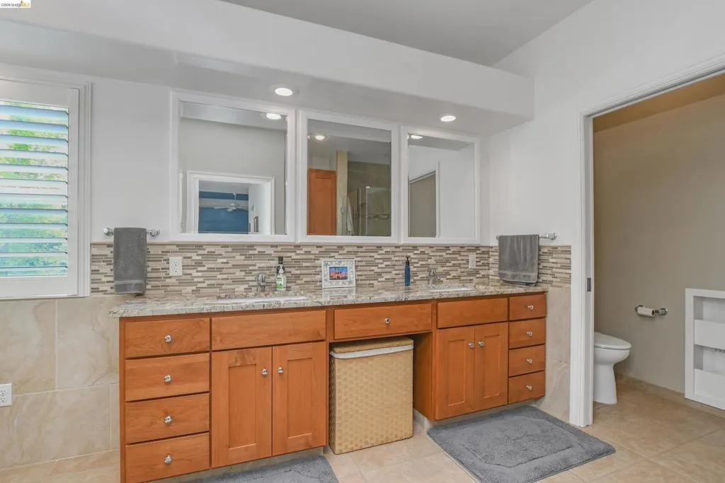 Bathroom with double vanity, light tile patterned floors, and recessed lighting