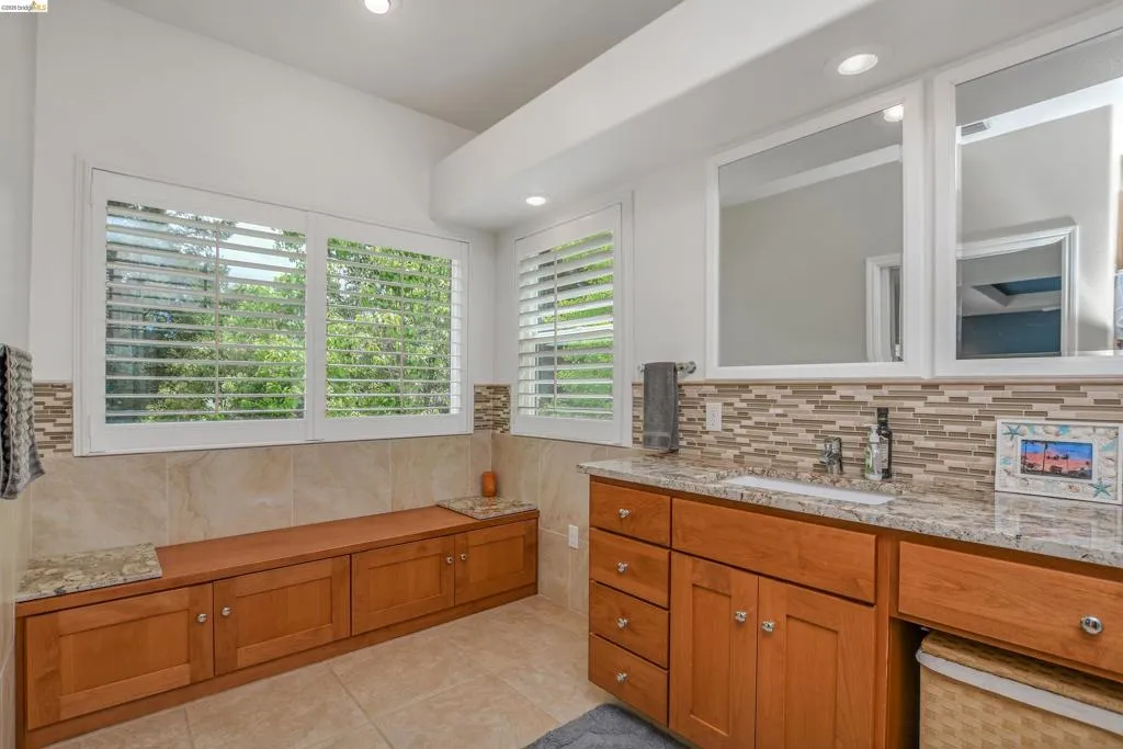Full bathroom with vanity, healthy amount of natural light, light tile patterned flooring, and recessed lighting