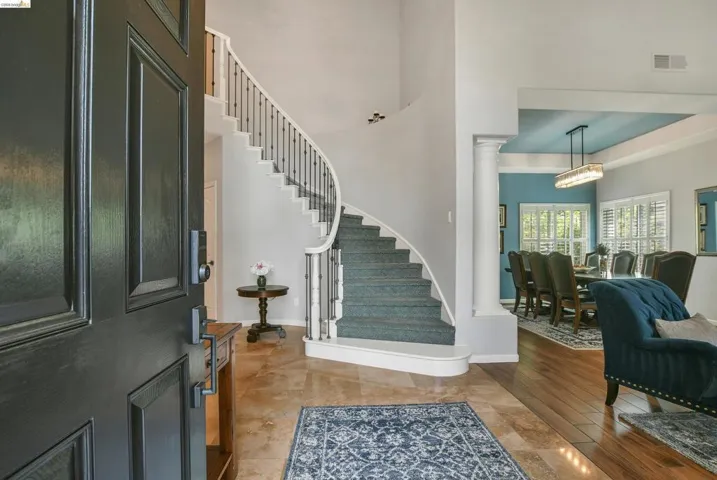 Foyer with decorative columns and light wood finished floors